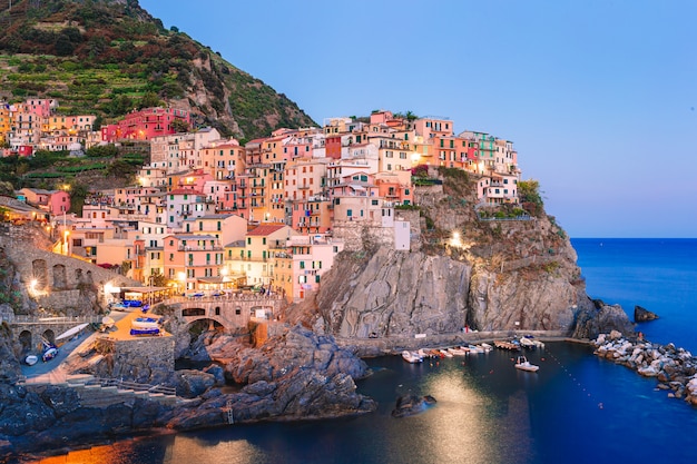 Stunning view of the beautiful and cozy village of Manarola in the Cinque Terre Reserve at sunset.