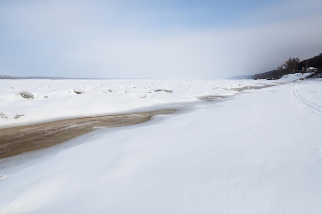 Stunning view of the frozen river covered with chunks of ice and white frosted snow Snowy desert