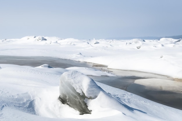 Stunning view of the frozen river covered with chunks of ice and white frosted snow Snowy desert