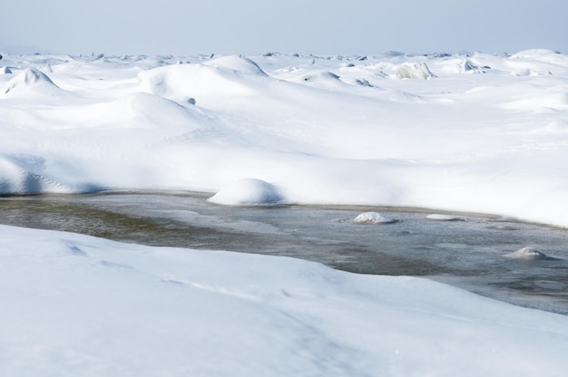 Stunning view of the frozen river covered with chunks of ice and white frosted snow snowy desert