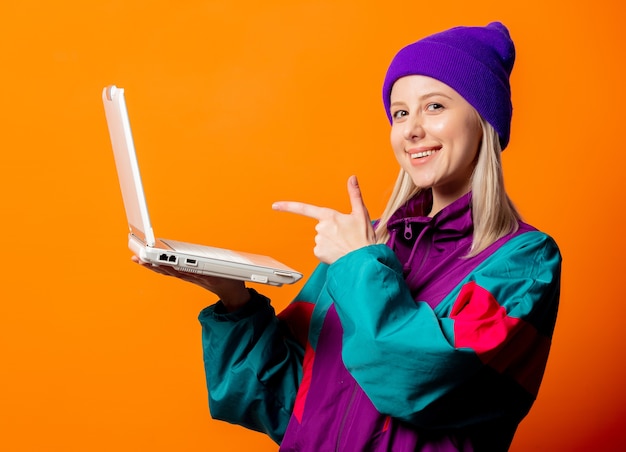 Style woman in 90s tracksuit with notebook on orange