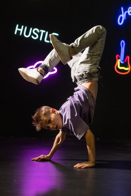 Stylish active guy in a purple Tshirt  having fun on neon signs background