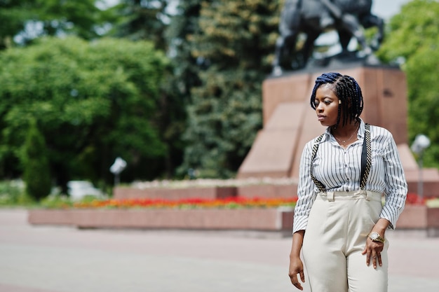 Stylish african american business woman at trousers with suspender and blouse posed outdoor