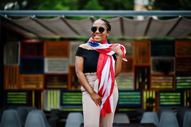 Stylish african american woman in sunglasses posed outdoor with usa flag