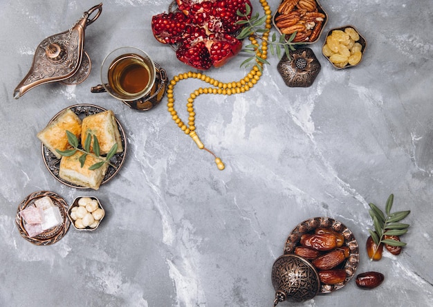 Stylish banner with traditional Arabic tableware and food sets cup of tea Koran and rosary