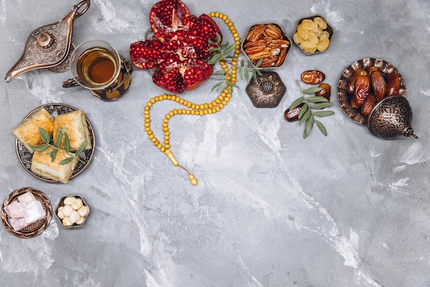 Stylish banner with traditional Arabic tableware and food sets cup of tea Koran and rosary