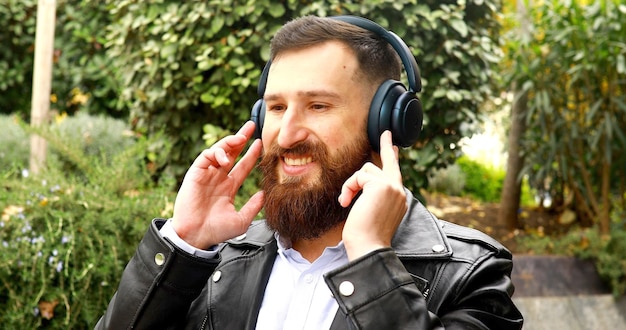 Stylish bearded man in headphones listening to music.