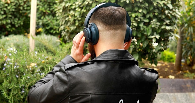 Stylish bearded man in headphones listening to music.