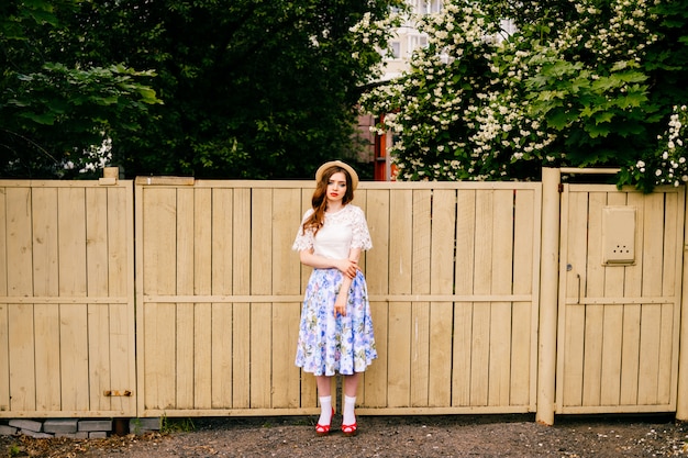 Stylish beautiful girl near the fence