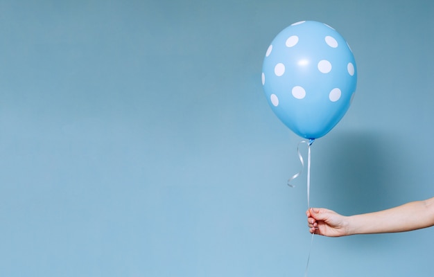 Photo stylish birthday party or holidays with balloons close up studio portrait . hand  holding blue colorful balloon indoor.