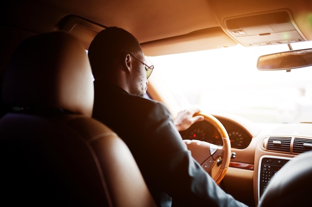 Stylish black man sitting behind the wheel of luxury car Rich african american businessman