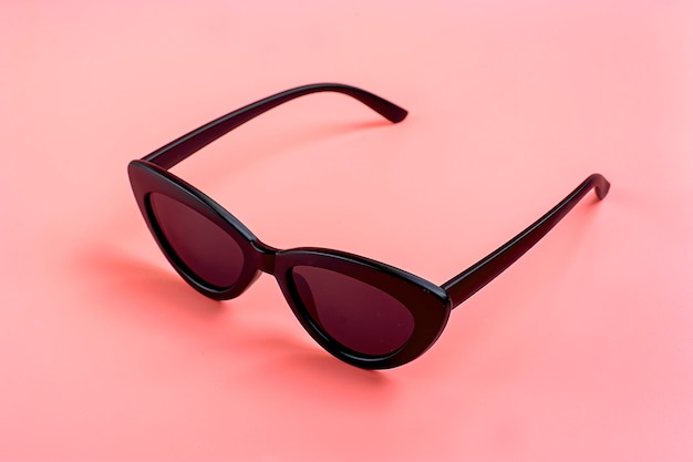 Stylish black sunglasses isolated on trendy pink 