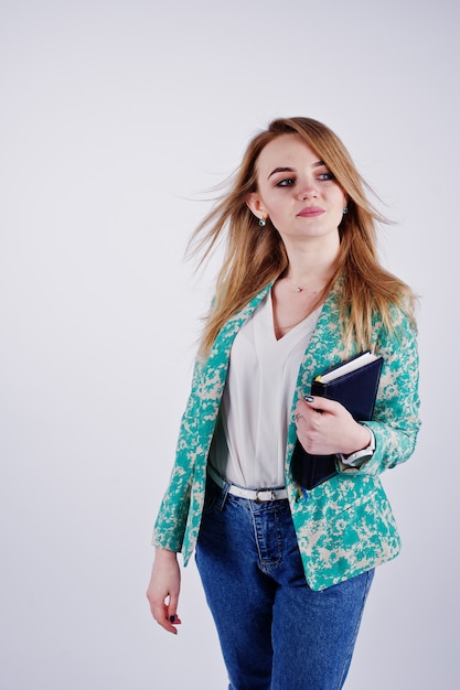 Stylish blonde girl in jacket and jeans with notebook diary at hands against 