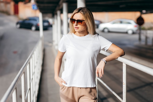 Stylish blonde girl wearing white t-shirt and glasses