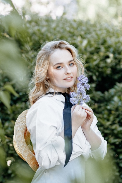 Stylish blonde woman in a blossoming garden