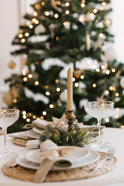 Stylish bright interior of the living room with a Christmas tree and a festive table