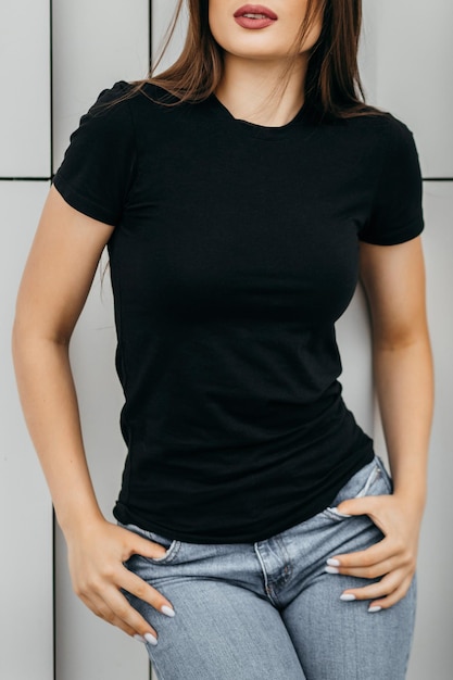 Stylish brunette girl wearing black tshirt and glasses posing against street  urban clothing style