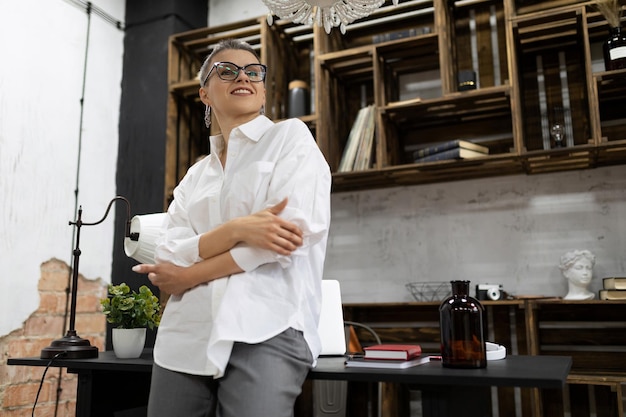 Stylish business european woman in a white shirt and glasses looks into the distance with confidence