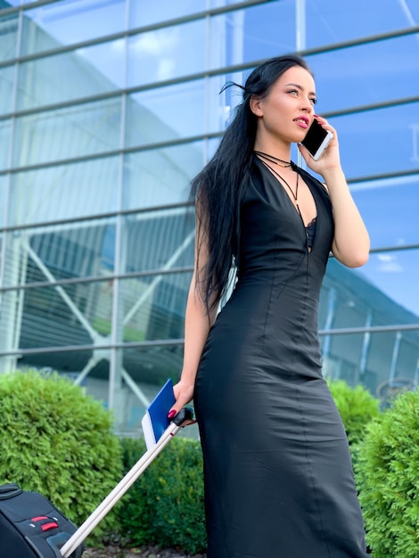 Stylish businesswoman with luggage at the airport