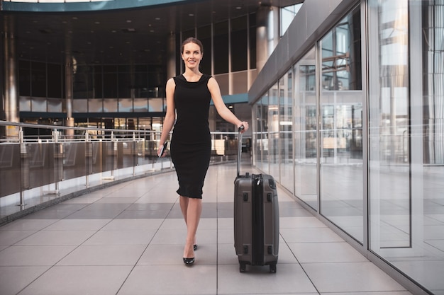 Stylish businesswoman with luggage at the airport