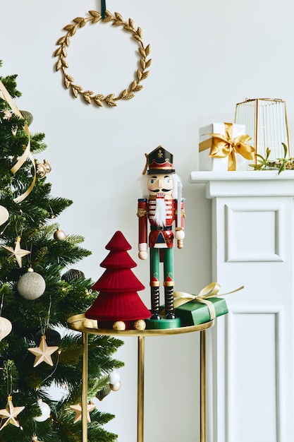 Stylish christmas composition at living room interior with white chimney, christmas tree and wreath, stars, gifts and decoration. Santa clause is coming. Template.