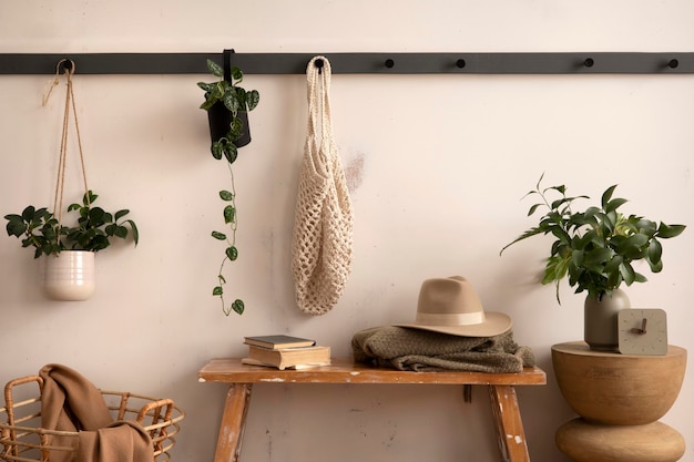 The stylish composition of cosy entryway with grey bench coffee table hanger and personal accessories Beige wall Home decor Template