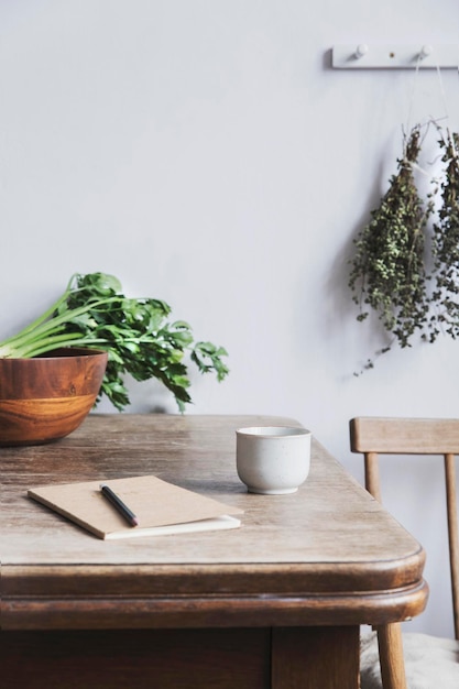 Stylish composition of creative dining room interior design with wooden table and chair bakets and other kitchen accessories Neutral walls Template Copy space