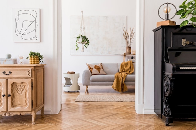 Stylish composition of creative spacious apartment interior with grey sofa, coffee table, plants, carpet and beautiful accessories. White walls and parquet floor.