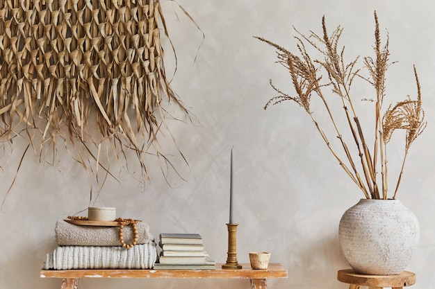 Stylish composition of living room interior with copy space, bench in retro style, clay vases and crockery. Rustic inspiration. Summer vibes. Beige wall. Template.