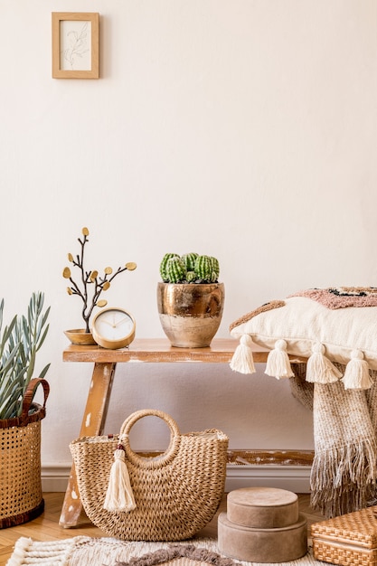 Stylish composition of living room interior with mock up frame, wooden bench, pillow, plaid, rattan basket, plants, decortaion, copy space and elegant personal accessories in modern home decor.