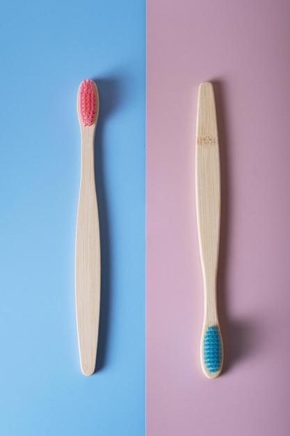 Stylish concept with bamboo toothbrushes on pink and blue background