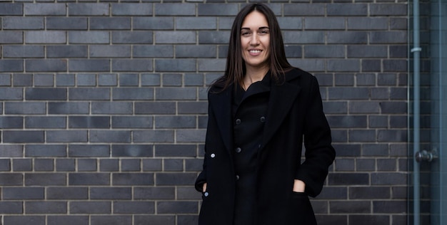 Stylish confident woman lawyer against brick wall background