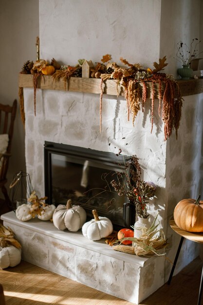 Photo stylish decoration of fireplace with pumpkins autumn leaves nuts candle on rustic wood in modern farmhouse living room autumn decor on fireplace mantel thanksgiving and halloween