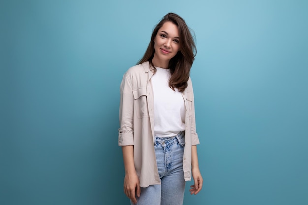 Stylish dreamy year old female person in elegant look smiling on blue background