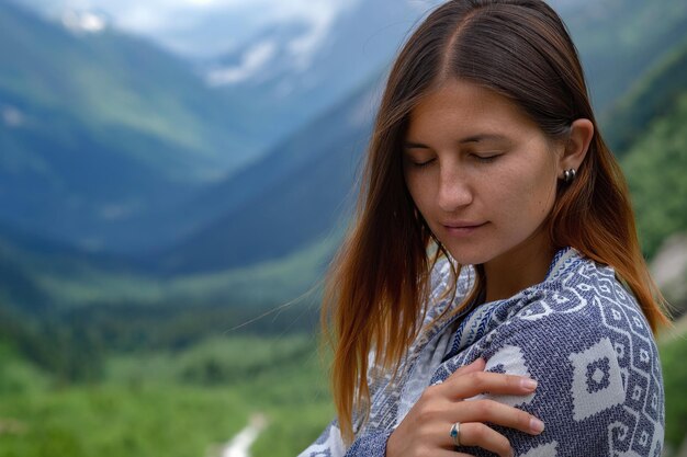 Stylish female hipster walking on top of mountains