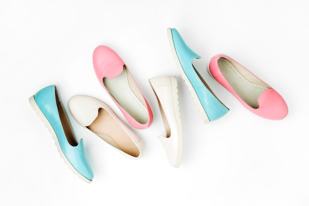 Stylish female shoes in pastel colors on white background, top view