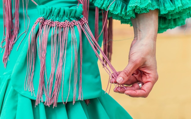 Stylish flamenco woman with green vintage cloth handbag with fringes