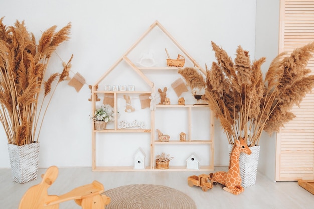 Stylish furniture in a bright spacious children's room with a wooden rocking horse white children's room in Scandinavian style