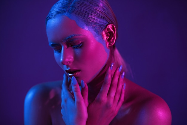 Stylish girl model in neon shade with lowered eyes