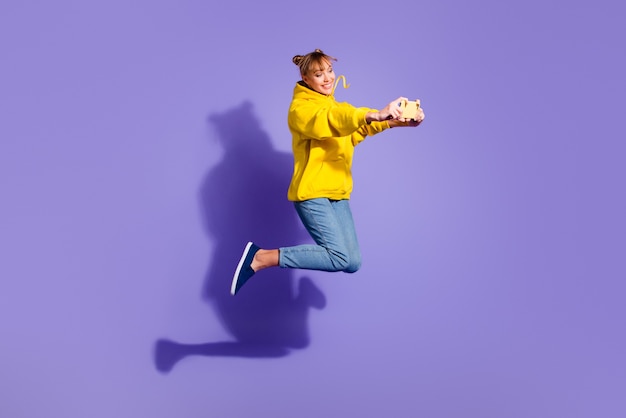 Stylish girl posing against the purple wall