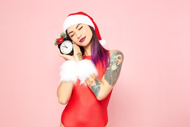 Stylish girl in a red swimsuit and a Santa Claus hat. Christmas mood