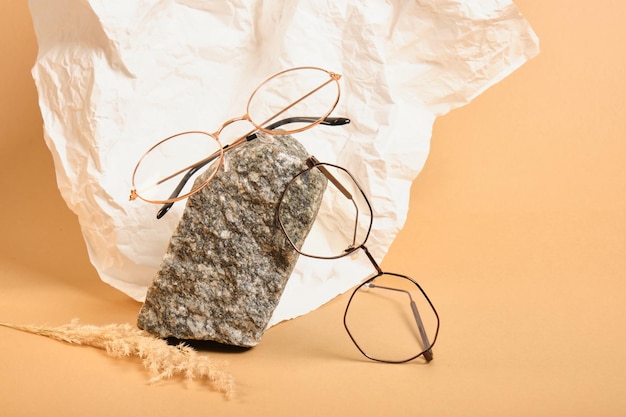 Stylish glasses on a stone on a background of crumpled white paper, trendy still life, accessories for vision correction