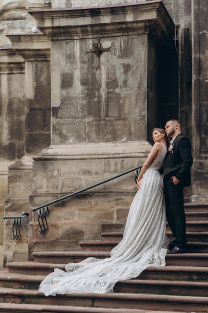 Stylish groom hugs from behind beautiful bride