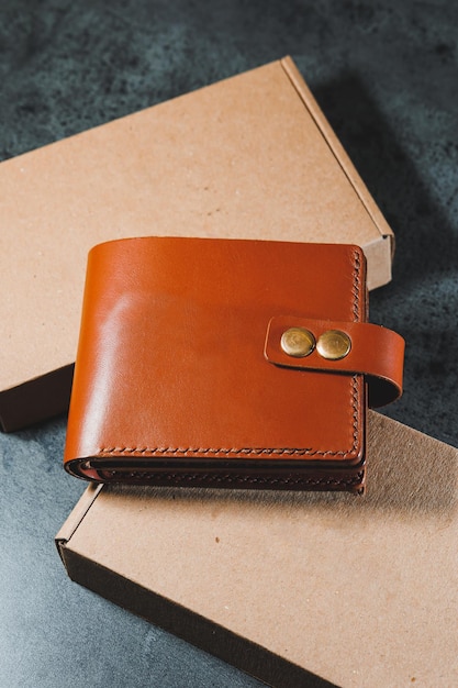 Stylish handmade brown leather wallet on a gray background Product made of genuine leather