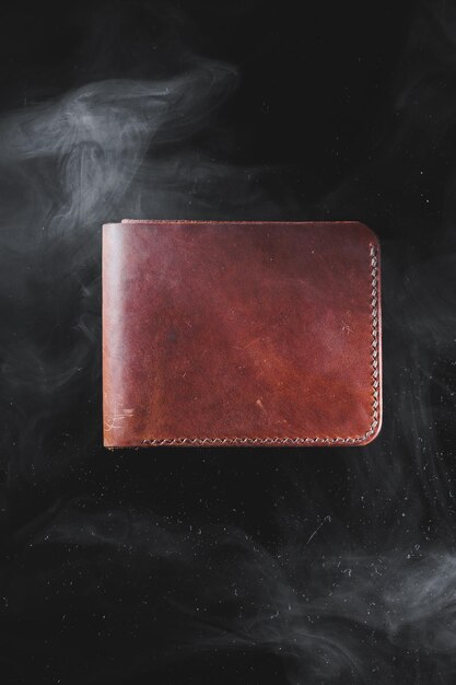 Stylish handmade brown leather wallet on a gray background Product made of genuine leather