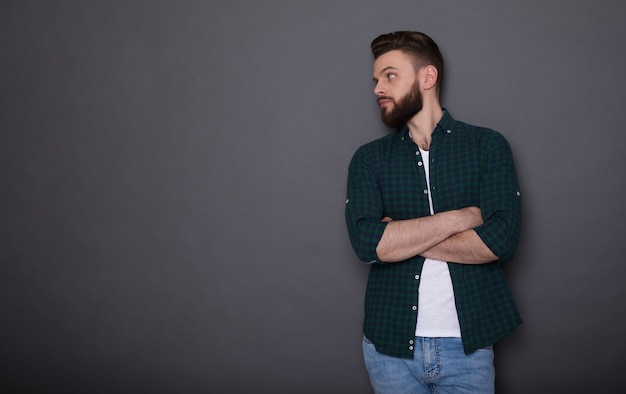 Stylish handsome trendy fashion bearded man in denim wear is posing 