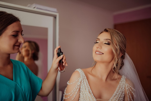 Stylish happy bride dressing in dress smiling to bridesmaids at window rustic wedding morning preparation bridal getting ready emotional moment space for text black white photo