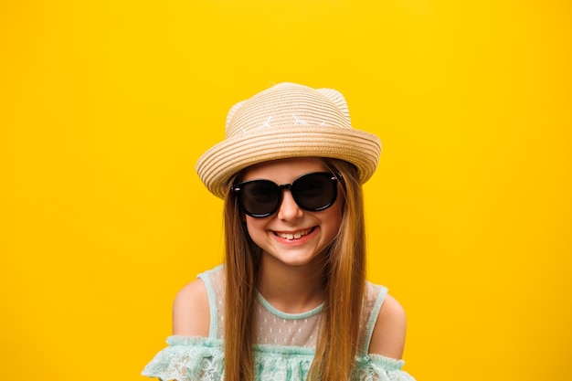 Stylish happy fun child blond girl with sunglasses and hat