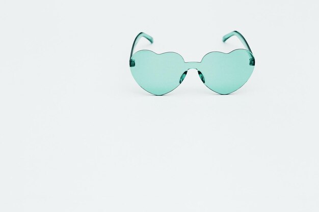 Stylish  heart shaped glasses on paper background with copy space  Beautiful trendy sunglasses