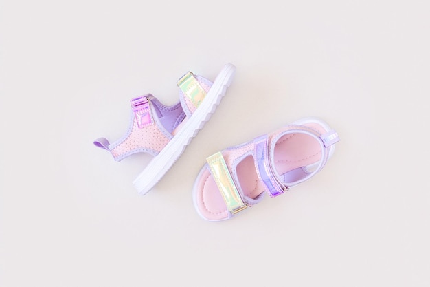 Stylish holographic sandals for kids on grey background Shiny fashion summer shoes Flat lay Top view